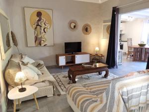 a living room with a couch and a table at Appartement au coeur d'Orient Bay avec terrasse jardin Jacuzzi et citerne in Orient Bay