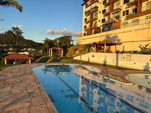 a swimming pool in front of a building at A Melhor vista de água de Lindóia in Águas de Lindóia