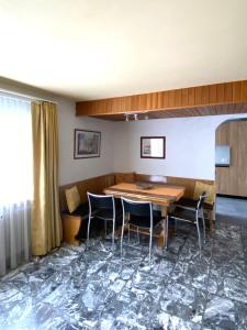 una sala da pranzo con tavolo e sedie su un pavimento in marmo di Chalet Alm a Zermatt
