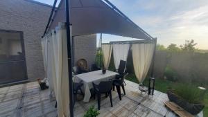 an umbrella on a patio with a table and chairs at La Maison De Marie in Binche