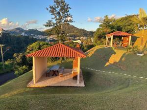 A Melhor vista de água de Lindóia في أغواس دي يندويا: شرفة مع طاولة نزهة على تلة