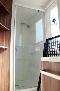 a glass shower door in a room with at Mobilhome « Destination de vacances» in Sigean