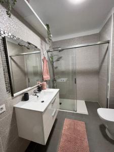 een badkamer met een witte wastafel en een douche bij Aloha - Costa del Silencio in Arona