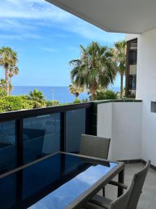 een balkon met een tafel en stoelen en de oceaan bij Aloha - Costa del Silencio in Arona