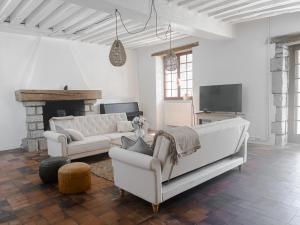 un soggiorno con 2 divani bianchi e un camino di Maison de charme, grand SPA JACUZZI, WIFI Fibre & Netflix 