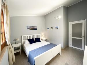 una camera da letto con un letto bianco e lenzuola blu di Villa SALMAGI a Terra Mala