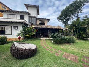 ブジオスにあるCasa em geribáの芝生に籐のソファが置かれた庭のある家