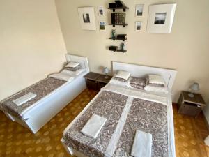 two beds in a room with two tables at Aloft House in Kutaisi