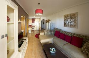 プラヤ・フラメンカにあるFlamenca Holidaysのリビングルーム(ソファ、赤い枕付)