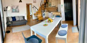 a living room with a white table and blue chairs at Villa Maracuya in Lajares