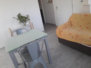 uma sala de estar com uma mesa e uma cadeira em Chez Mary em Vanosc