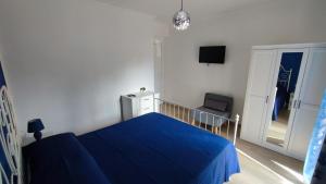 a bedroom with a blue bed and a chair at Casa vacanze Tortolì in Tortolì