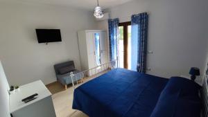 a bedroom with a blue bed and a tv at Casa vacanze Tortolì in Tortolì