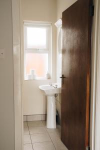 baño con lavabo y ventana en Donegal Estuary Holiday Homes en Donegal