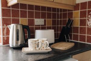 two coffee mugs sitting on a counter in a kitchen at Donegal Estuary Holiday Homes in Donegal