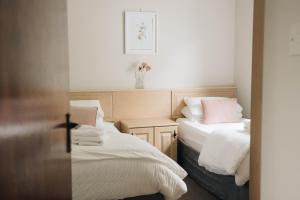 1 dormitorio con 2 camas con sábanas blancas y almohadas rosas en Donegal Estuary Holiday Homes, en Donegal