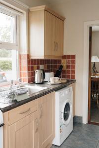 a kitchen with a sink and a washing machine at Donegal Estuary Holiday Homes in Donegal