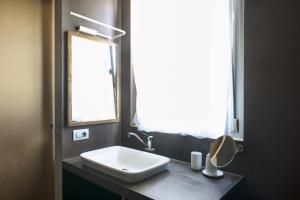 a bathroom with a white sink and a window at Coroncina in Belforte del Chienti