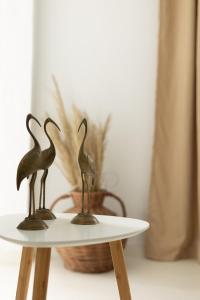 two statues of birds sitting on top of a table at Theo Bungalows Boutique Hotel in Kriopigi