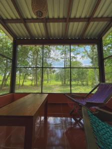 una mesa y una silla en una habitación con una ventana grande en Ecohabitat, en Xpujil