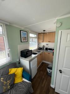 eine kleine Küche mit einer Couch in einem Zimmer in der Unterkunft Once Upon a Tide - Bridlington Chalet in Bessingby