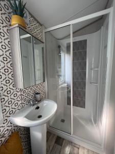 biała łazienka z umywalką i prysznicem w obiekcie Porthcurno 4, Silverbow Country Park w mieście Perranzabuloe