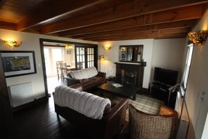 a living room with a couch and chairs and a television at Easdale Cottage in Ellanbeich