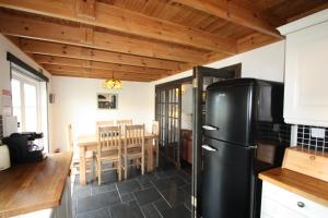 a kitchen with a black refrigerator and a table at Easdale Cottage in Ellanbeich