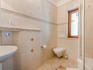 łazienka z umywalką, toaletą i oknem w obiekcie Apartament Marysieńka w Kątach Rybackich