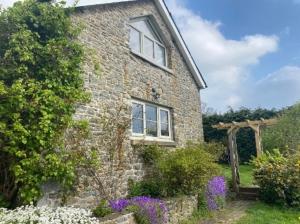 a brick house with a window and a garden at Pippin Lodge in Llanwrda