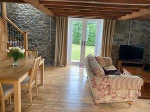 a living room with a couch and a table at Pippin Lodge in Llanwrda