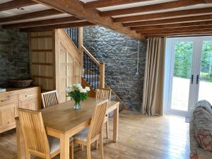 a dining room with a wooden table and chairs at Pippin Lodge in Llanwrda
