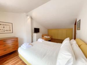 um quarto com uma grande cama branca e uma cómoda em Villetta Vinci em Pietrasanta