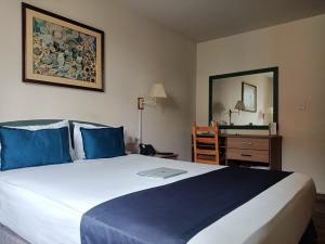 Hotel San Isidro Inn في ليما: غرفة نوم مع سرير مع لاب توب عليه
