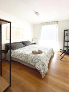 SuitesFlores - Bright and cozy apartment in Verona في فيرونا: غرفة نوم بسرير كبير مع أرضية خشبية
