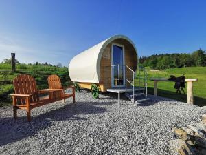 una casa pequeña con porche y 2 sillas en Cowboy's Land en Višnja Gora