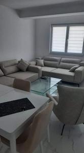 uma sala de estar com um sofá, uma mesa e cadeiras em Apartman Tamara Struga em Struga