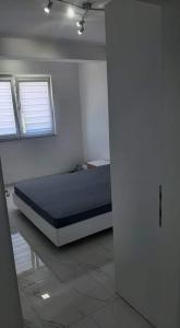 una camera con un letto in una stanza con due finestre di Apartman Tamara Struga a Struga