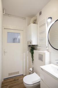 bagno con servizi igienici, lavandino e specchio di Cosy Apartment in Sopot a Sopot