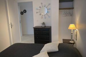 - une chambre avec un lit, une commode et un miroir dans l'établissement Les Sardinières, à Le Relecq-Kerhuon