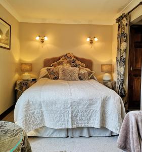 a bedroom with a white bed with two lamps at Maywalk House B&B in Eyam