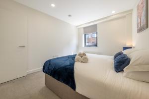 a bedroom with a large white bed with a window at Luxury One Bedroom Serviced Apartment in the Heart of Bedford in Bedford