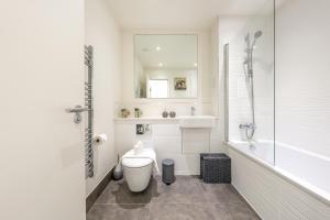 a bathroom with a toilet and a tub and a sink at Luxury One Bedroom Serviced Apartment in the Heart of Bedford in Bedford