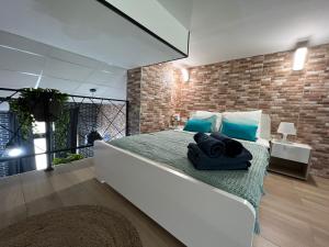 a bedroom with a large bed with a brick wall at Grandera Apart`s - Melià i Fuster 23С in Valencia