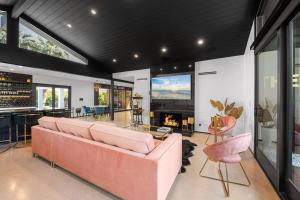 THE BANK Mid-Century Luxury Resort Palm Springs في بالم سبرينغز: غرفة معيشة مع أريكة وردية ومدفأة
