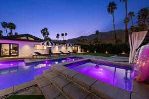 THE BANK Mid-Century Luxury Resort Palm Springs في بالم سبرينغز: حمام سباحة مع أضواء أرجوانية في منزل