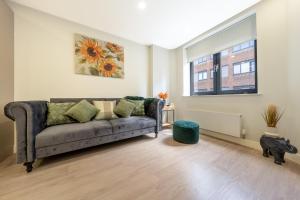 a living room with a couch and a window at Luxury One Bedroom Serviced Apartment in the Heart of Bedford in Bedford