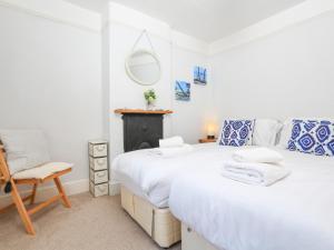 2 camas en una habitación con silla y espejo en Crew House en Dartmouth