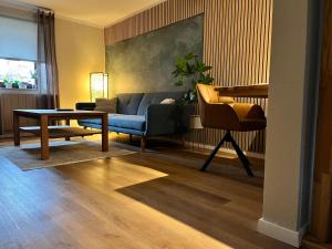 een woonkamer met een blauwe bank en een tafel bij Suite SZ-Lichtenberg in Salzgitter