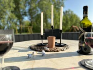 a table with two candles and a bottle of wine at Nordseeperle-Ferienhaus in Otterndorf